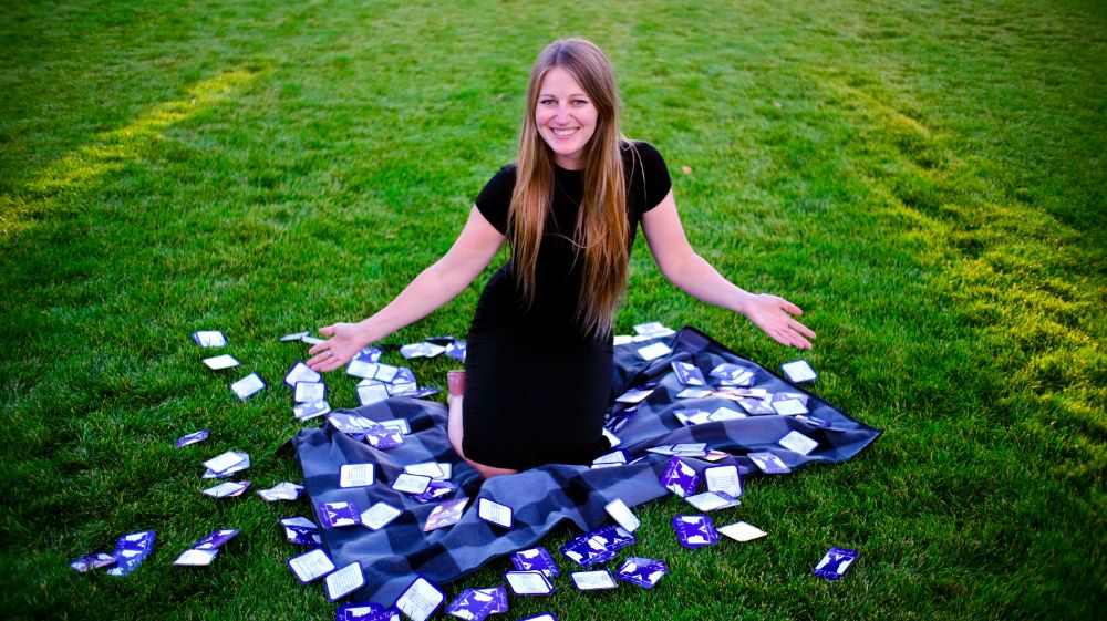 Janae sitting on blanket on grass with Touch & Tell cards spread out around her